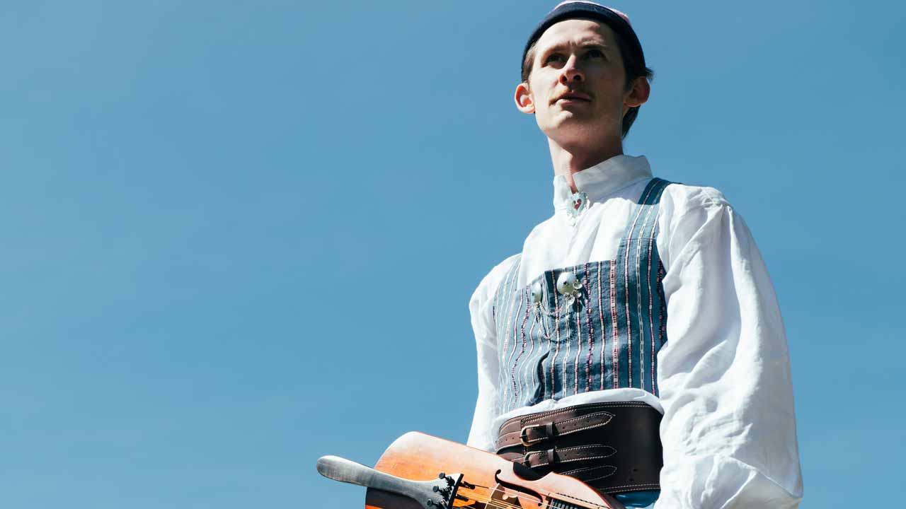 En folkmusiker i dräkt och nyckelharpa