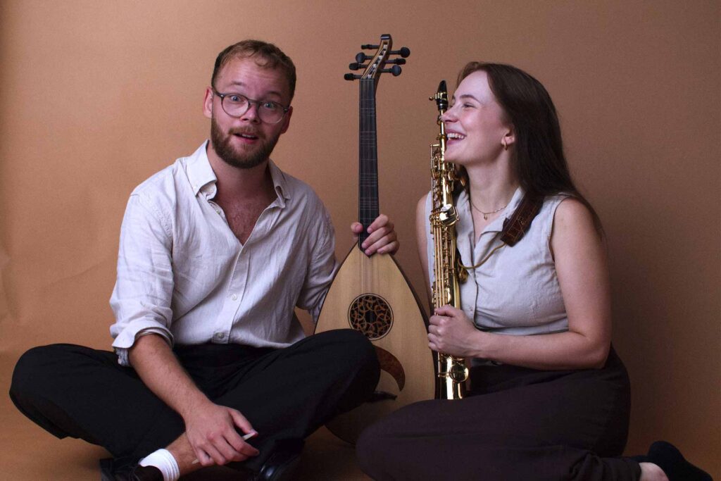 Två musiker som sitter på golvet: Elian och Agnes