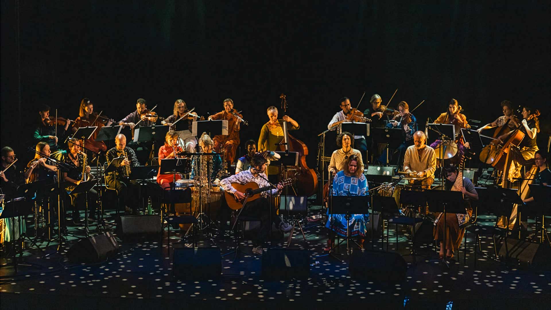 En mångkulturell orkester på en scen
