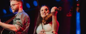 Två unga folkmusiker spelar på en scen