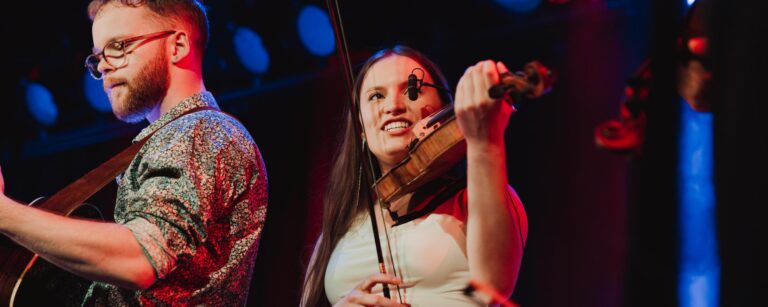 Två unga folkmusiker spelar på en scen